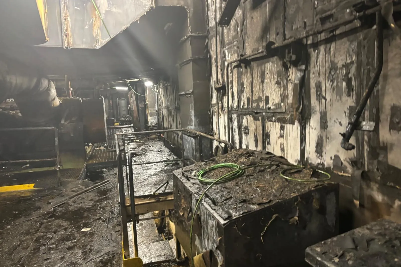 Interior de un buque con el cableado y los mamparos dañados por un incendio, antes de la reparación